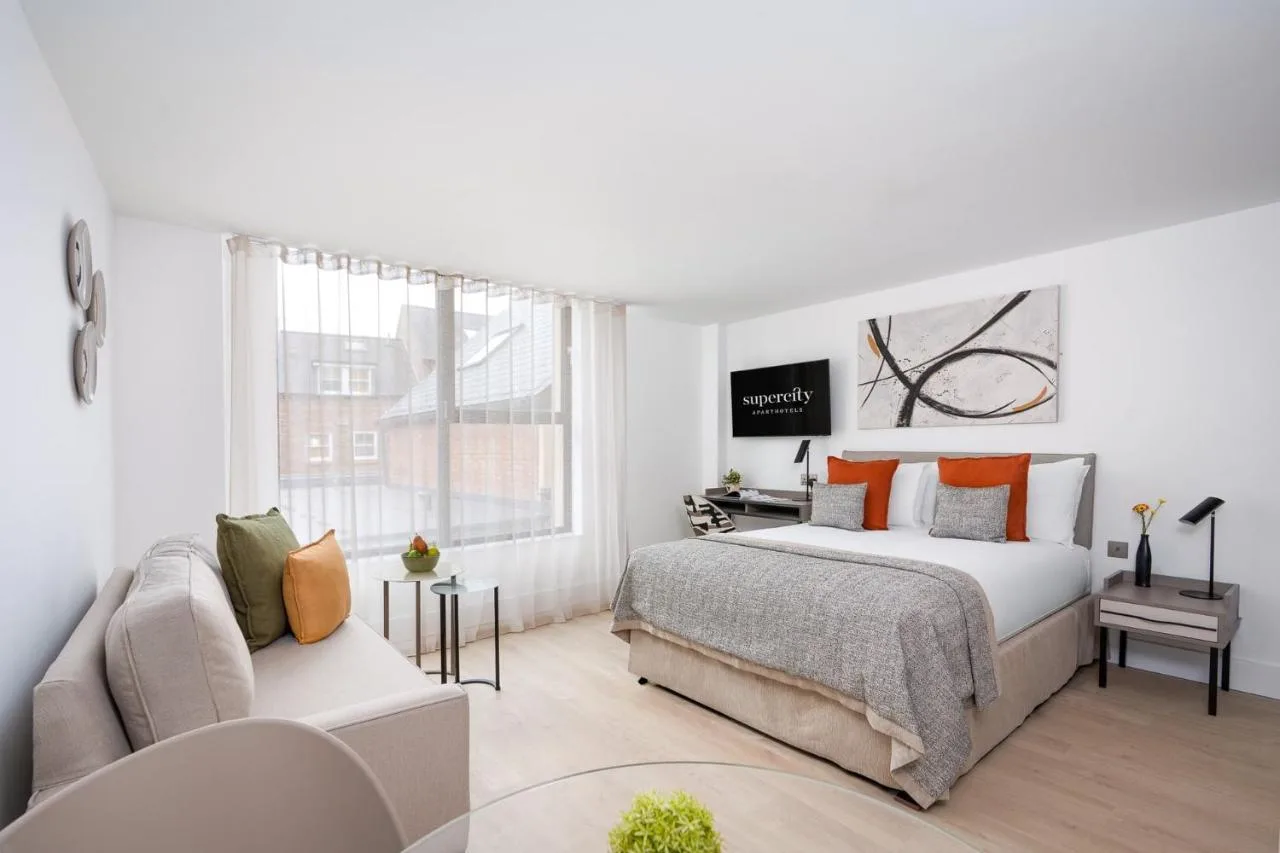 a white bedroom with a bed and a couch at Micklegate by Supercity Aparthotels in York